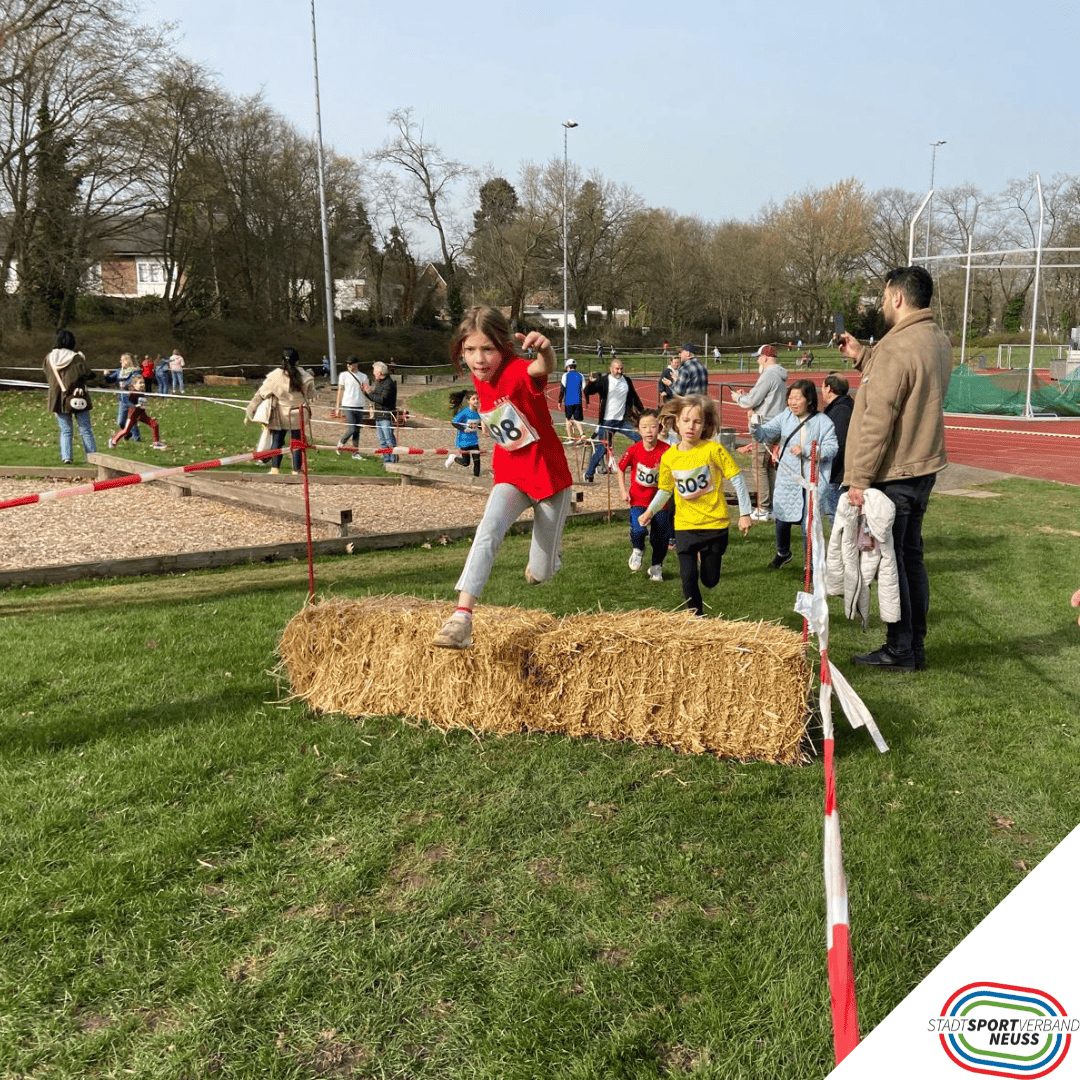 Ein Bild wo ein Kind über ein Heuballen springt